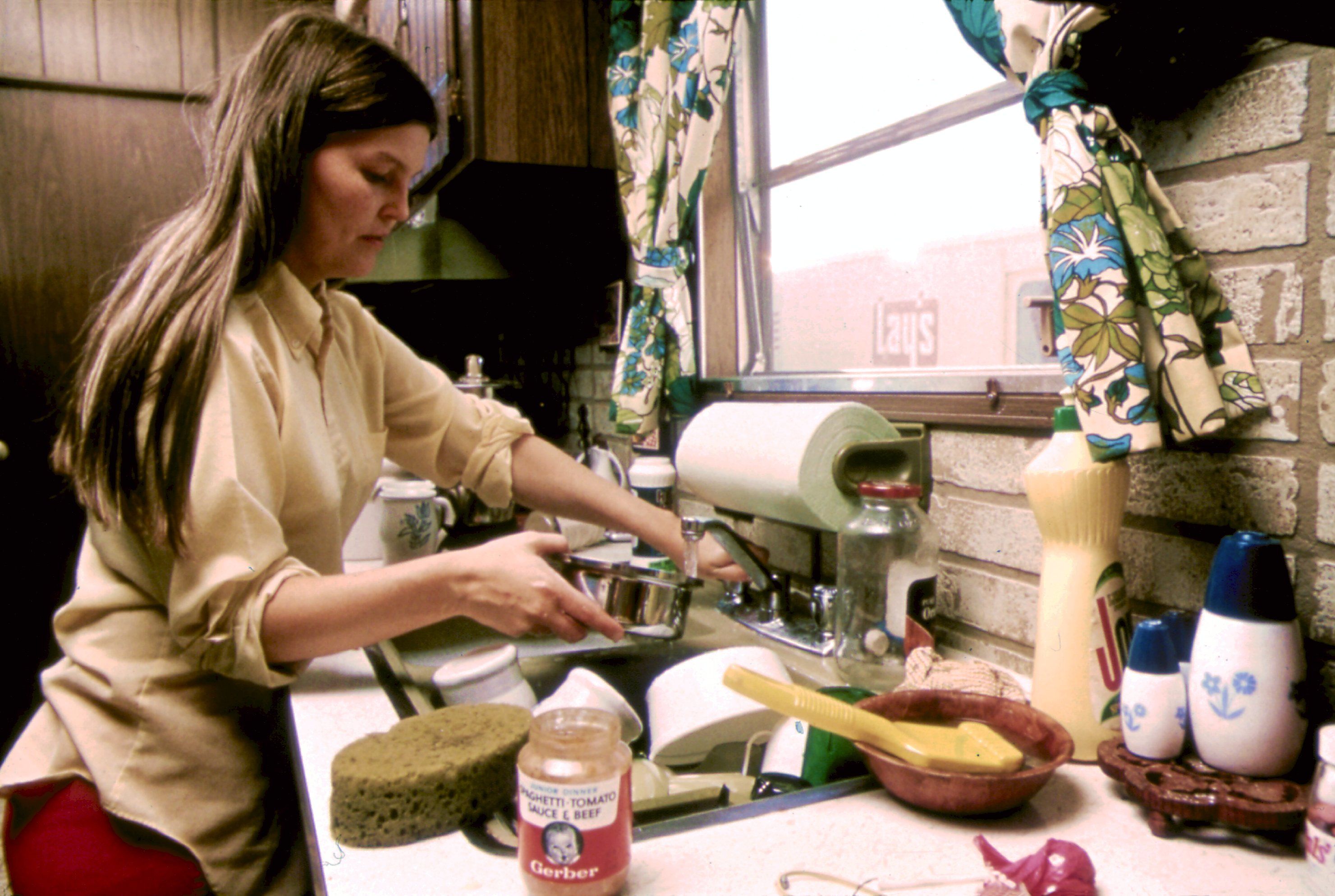 HOUSEWIFE_IN_THE_KITCHEN_OF_HER_MOBILE_HOME_IN_ONE_OF_THE_TRAILER_PARKS._THE_TWO_PARKS_WERE_CREATED_.jpg